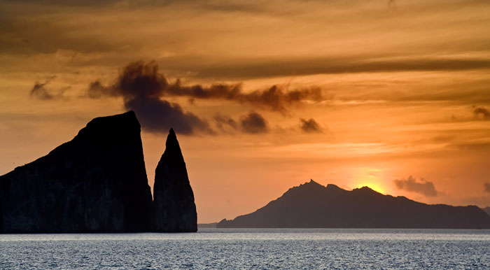 The sun setting over the ocean and some rock formations at San Bartolome in the Galapagos