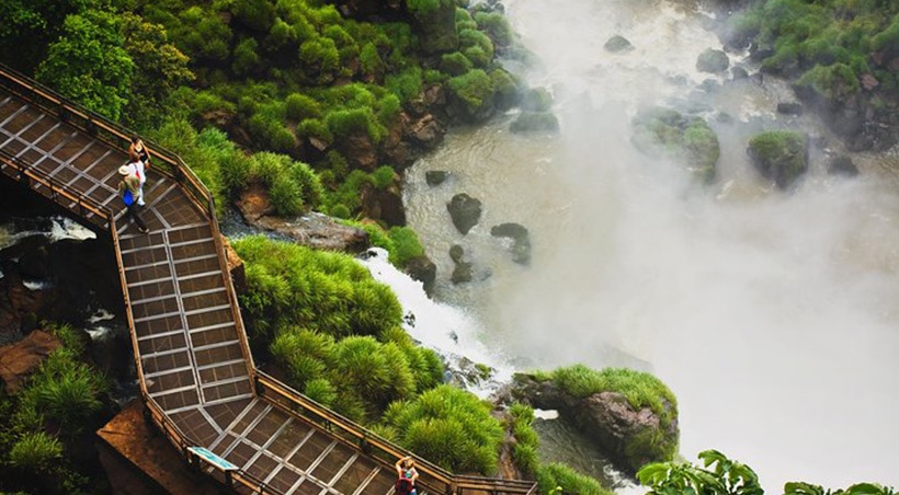 Visitors on a bridge admiring some of the lush vegetation of Iguazu National Park.