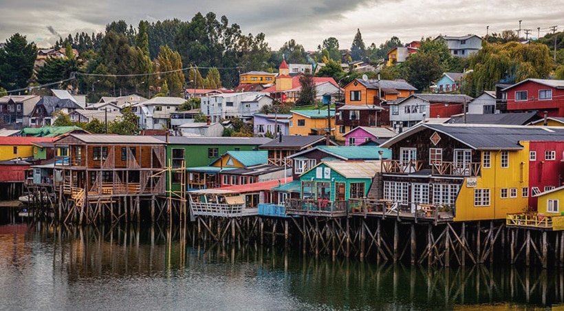 Colorful traditional stilt houses in the water on Chiloé Island in Chilean Patagonia.