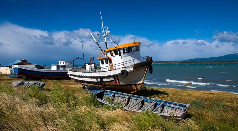 Small boats and canoes on the banks of the Señoret Channel near the town of Puerto Natales.