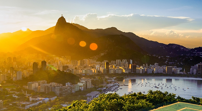 Sunrise over Rio de Janeiro, with the famous Christ the Redeemer statue visible in the distance.