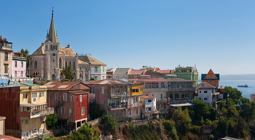 Colorful buildings and a church overlooking the Pacific Ocean in the coastal city of Valparaíso.