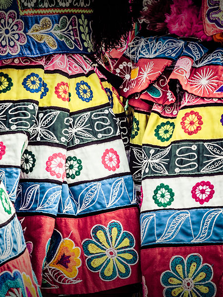 The colorful fabric of traditional Andean dresses on display at an artisan market in Cusco.