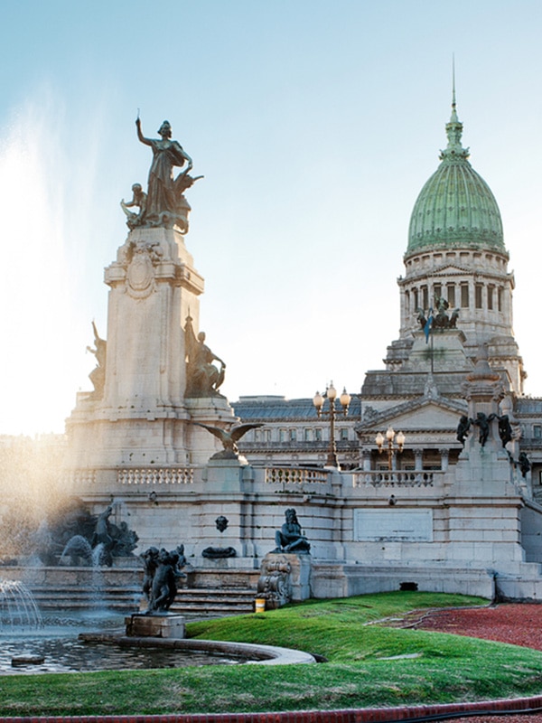 A water fountain and statues in front of the Palace of the Argentine National Congress.