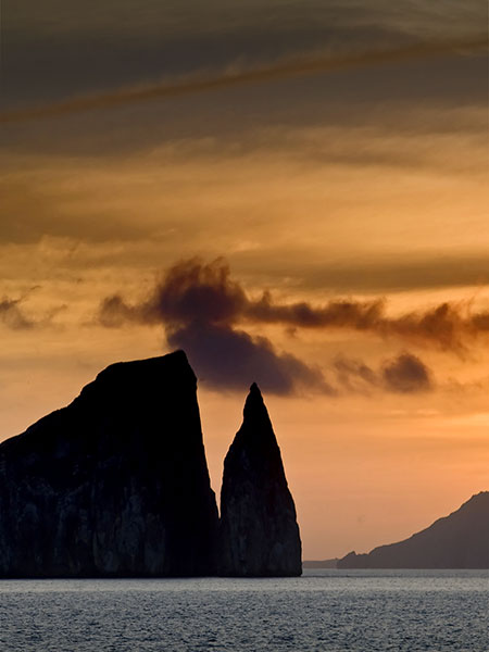 The sun setting over the ocean and some rock formations at San Bartolome in the Galapagos.