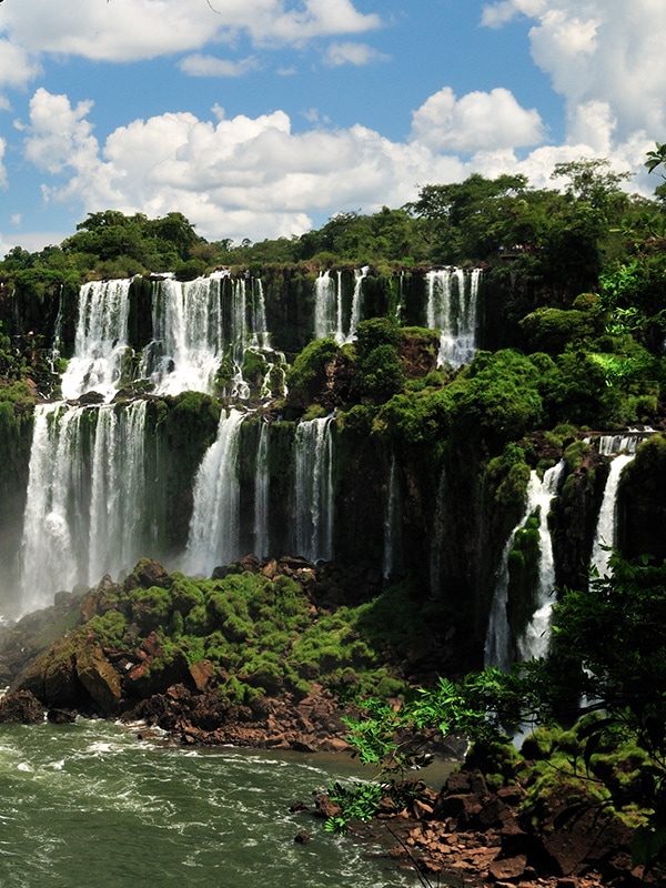 Lush green vegetation and waterfalls at Iguazu Falls, the largest waterfall in the world.