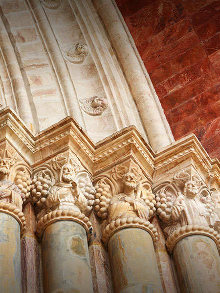 A series of pillars at a historic church in Quito featuring beautiful and ornate carvings.