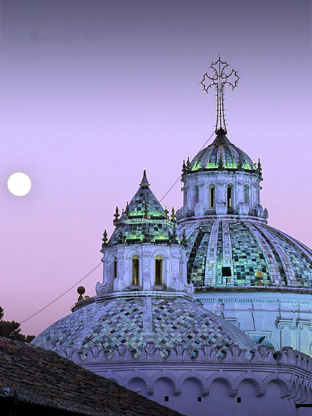 A purplish sky overlooking the domes of the historic Compania de Jesus church in Quito.