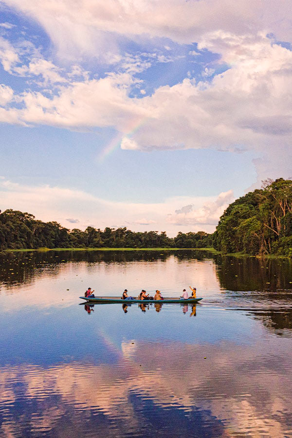 A group of visitors observing the jungle from a canoe in the Ecuadorian Amazon Rainforest.