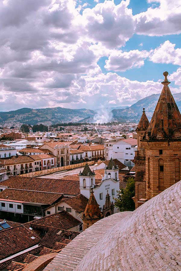 A view of the city of Cuenca on a cloudy day as seen from the roof of a cathedral.