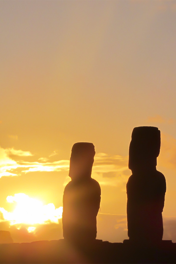 A silhouette of a row of the giant monolithic human figures known as moais on Easter Island.