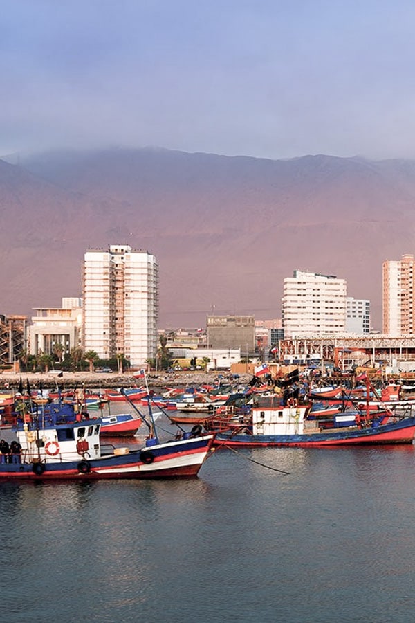 A number of small boats docked in the water off the coast of Iquique in northern Chile.