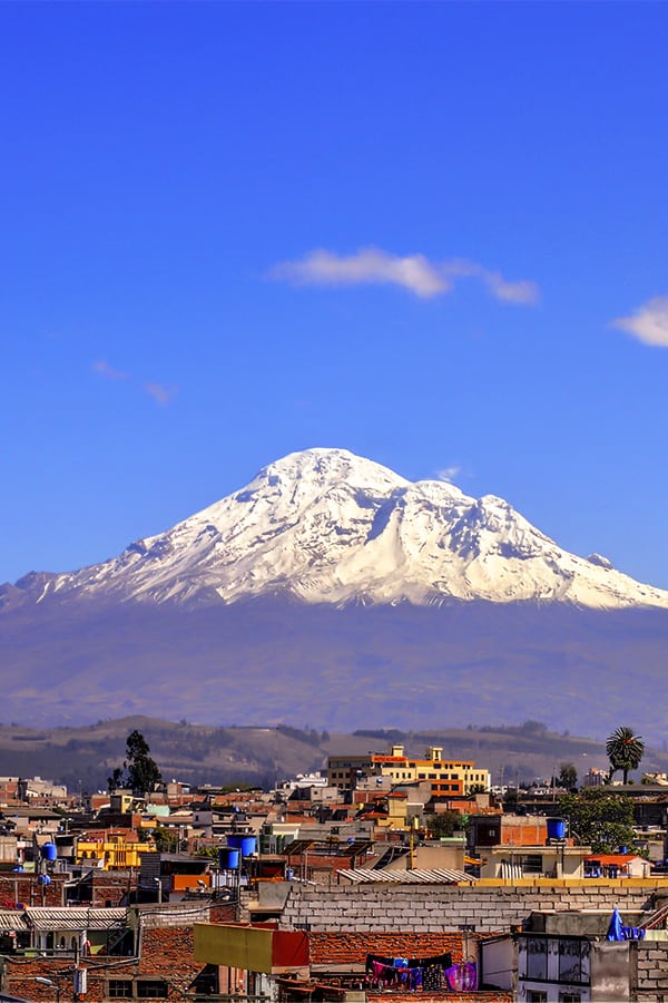 The iconic snow-capped Volcano Chimborazo overlooking the city of Riobamba in Ecuador.