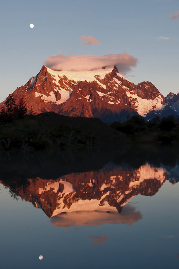 Snow-capped mountain peaks reflected in a lake in Torres del Paine National Park.