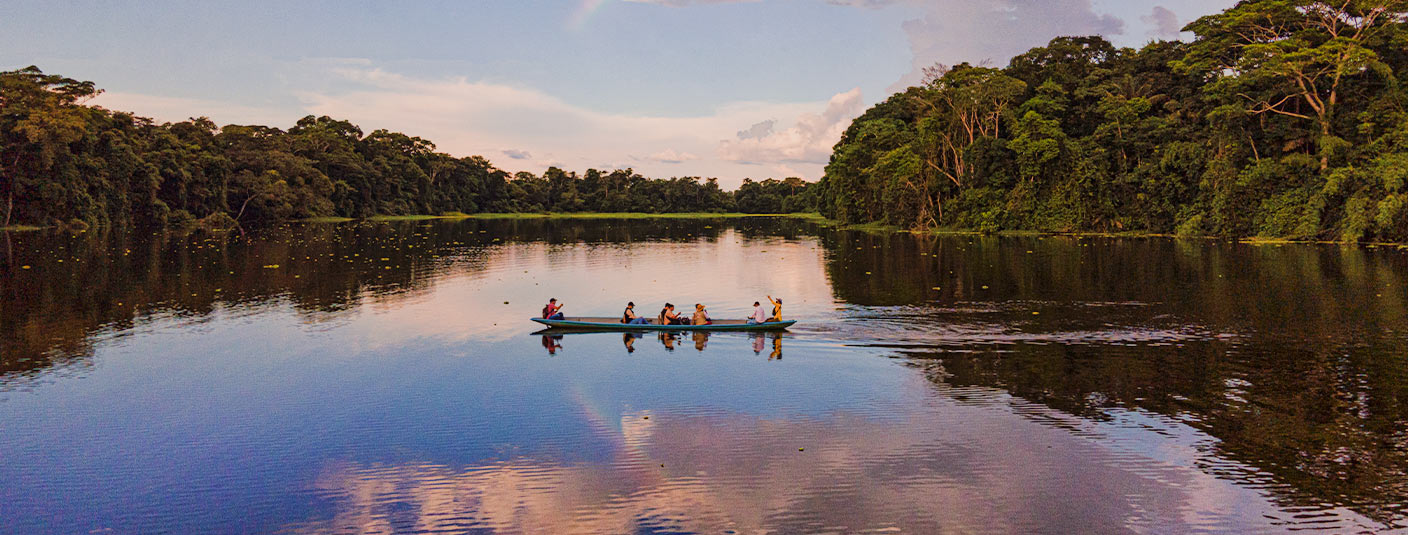 A group of visitors observing the jungle from a canoe in the Ecuadorian Amazon Rainforest.