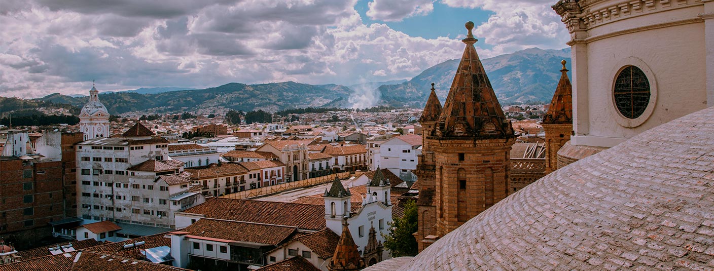 A view of the city of Cuenca on a cloudy day as seen from the roof of a cathedral.