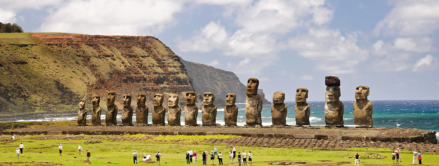 Visitors admiring a line of moais, the monolithic human figures found on Easter Island.