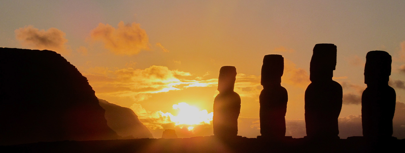 A silhouette of a row of the giant monolithic human figures known as moais on Easter Island.