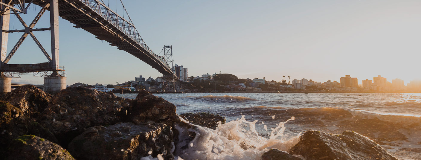 Waves splashing up onto some rocks underneath the Hercílio Luz Bridge in Florianopolis.