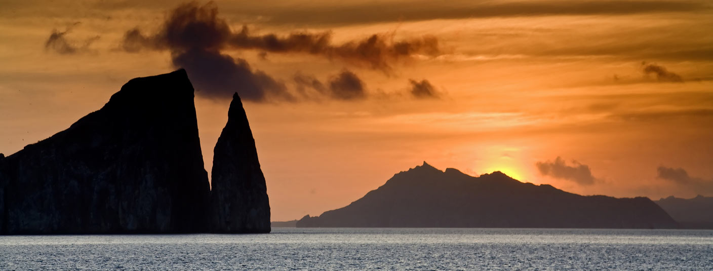 The sun setting over the ocean and some rock formations at San Bartolome in the Galapagos.