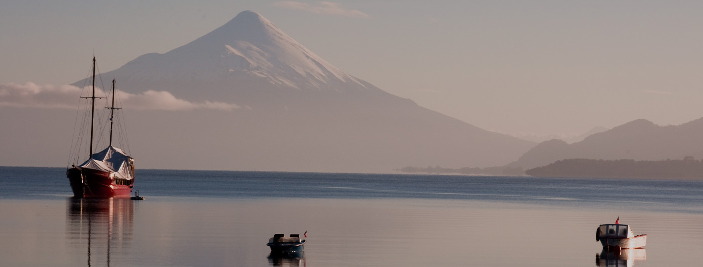 Boats in the water near Puerto Montt, with the massive Osorno Volcano visible in the background.