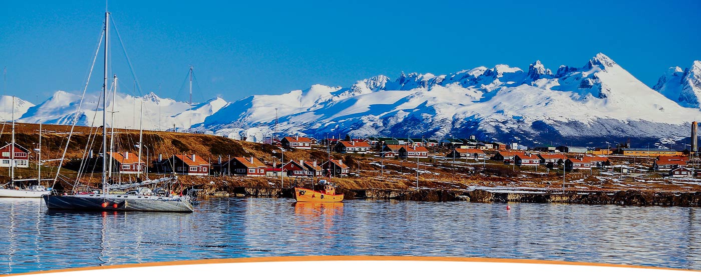 Boats in the Beagle Channel near Ushuaia with snow-capped Andean Mountains overhead.