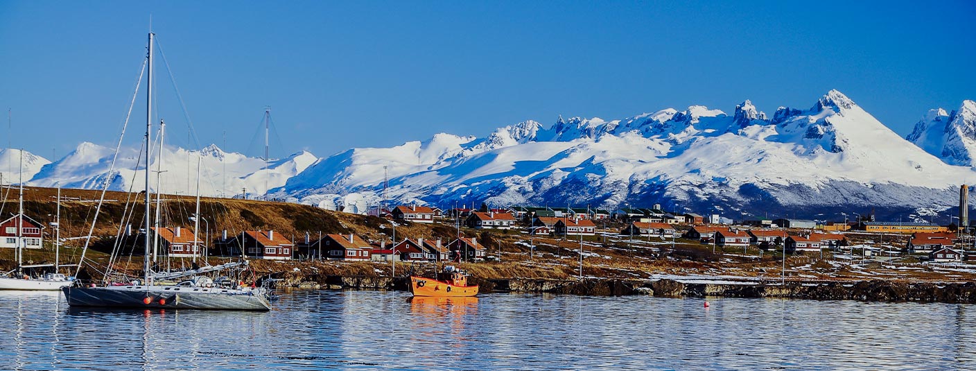 Boats in the Beagle Channel near Ushuaia with snow-capped Andean Mountains overhead.
