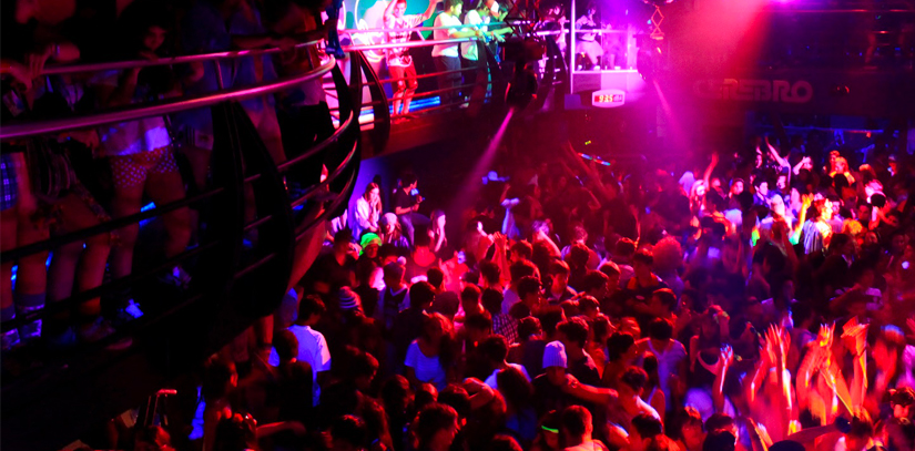 Cerebro nightclub packed full of people dancing with coloured lights in the town of Bariloche, Argentina