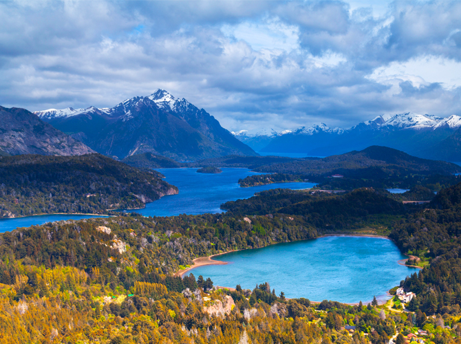 A wide shot landscape of Bariloche forest and surrounding lakes.