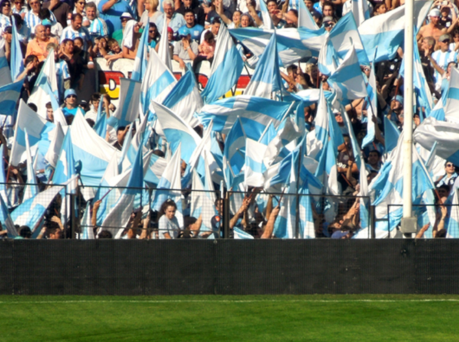 Football fans in the stadium waving the Argentinian flag