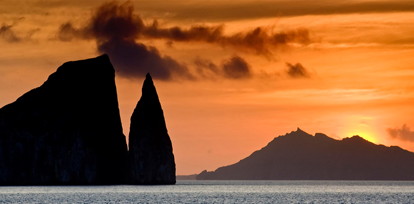 The sun setting over the ocean and some rock formations at San Bartolme in the Galapagos
