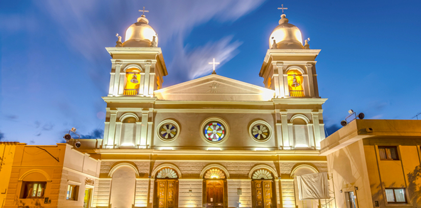 A lit up cathedral in front of a blue sky