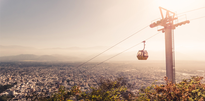 A cable cart over the city of Salta in northern Argentina, with the sunset in the background