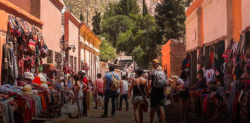 A crowd of people walking around a colorful artisanal market