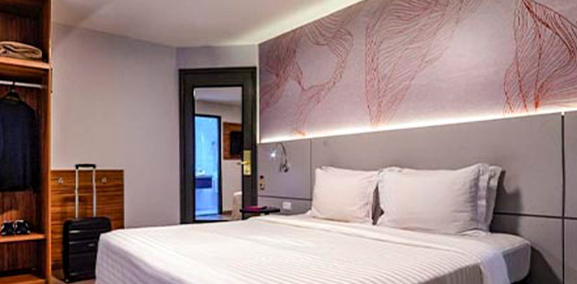 A large bed in a spacious modern room at the Intercity Interactive Jardins hotel in Sao Paolo