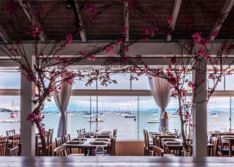 A beautifully-decorated restaurant with a view of boats on the water outside in Florianopolis.