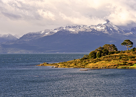 An inlet jutting into the water across from rolling Patagonian mountains in Ushuaia.