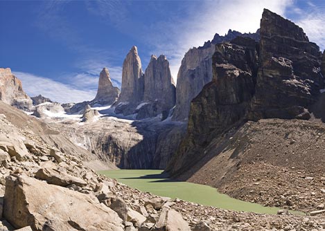 A green-tinted mountain lake overlooked by the iconic peaks of Torres del Paine.