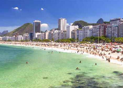 Modern buildings and crowds of people on the famous Ipanema Beach in Rio de Janeiro.
