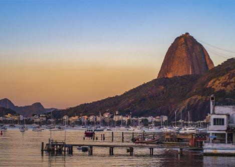 Rio de Janeiro’s iconic sugarloaf mountain, overlooking some docks lined with boats.