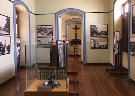 An artifact in a display case and mounted photographs at the Museum of Religious Art in Riobamba.