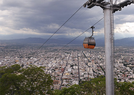 A cable car over the city of Salta in northern Argentina, with an overcast sky overhead.