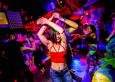 A couple dancing at a trendy nightclub in Salvador with other visitors dancing in the background.